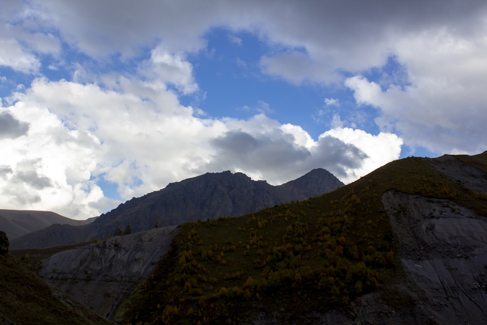 green and brown mountain under blue sky and white clouds during daytime