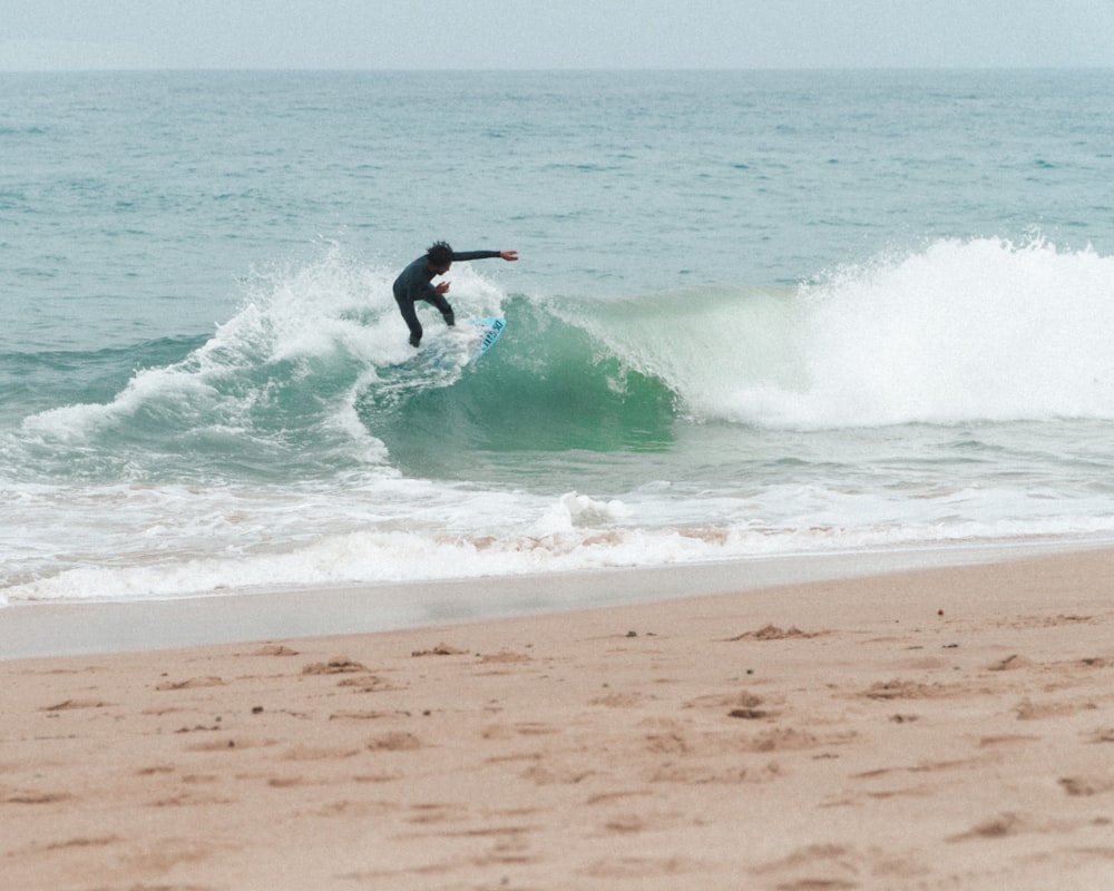 man surfing on sea waves during daytime