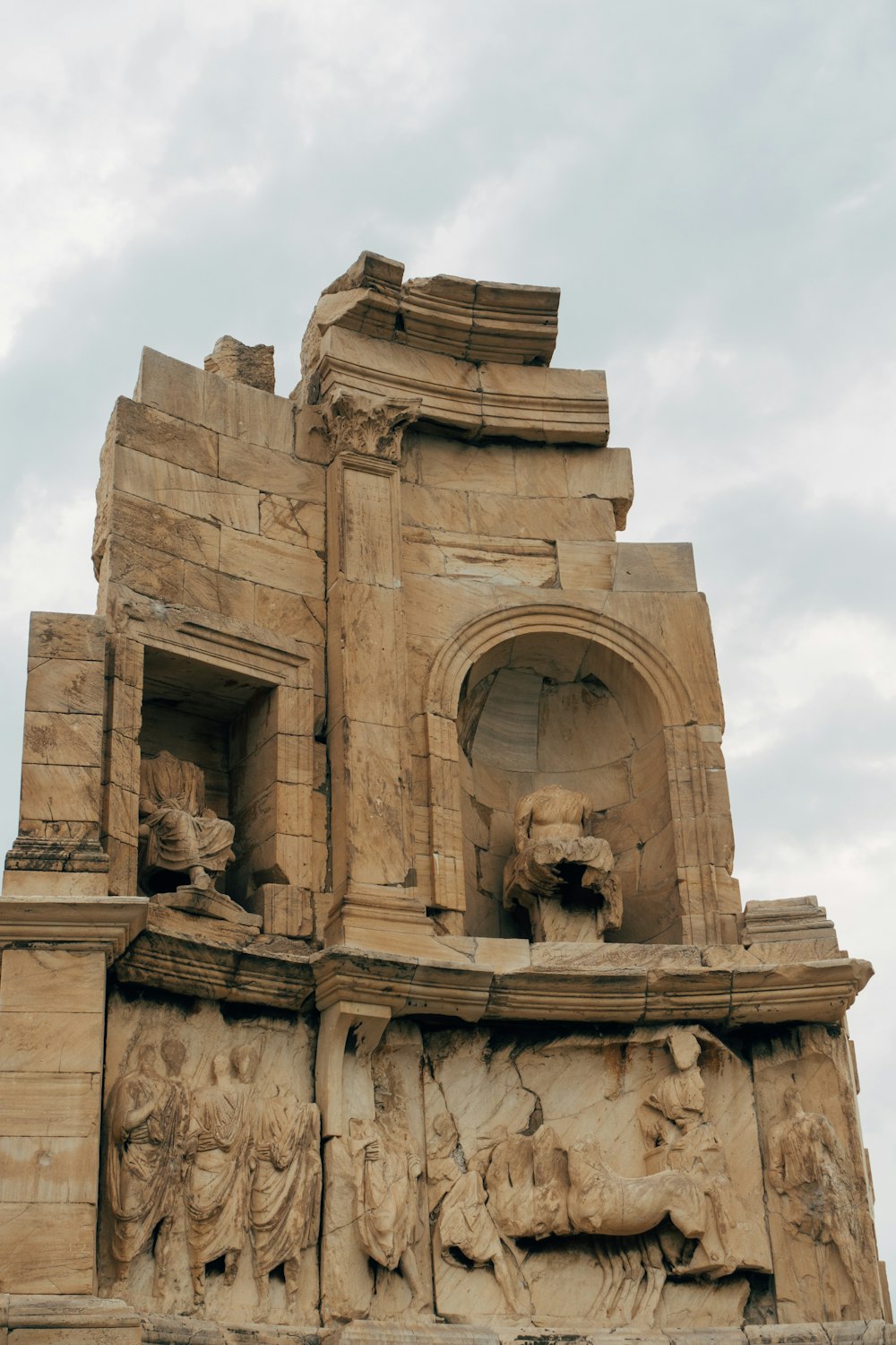 brown concrete statue under white clouds during daytime