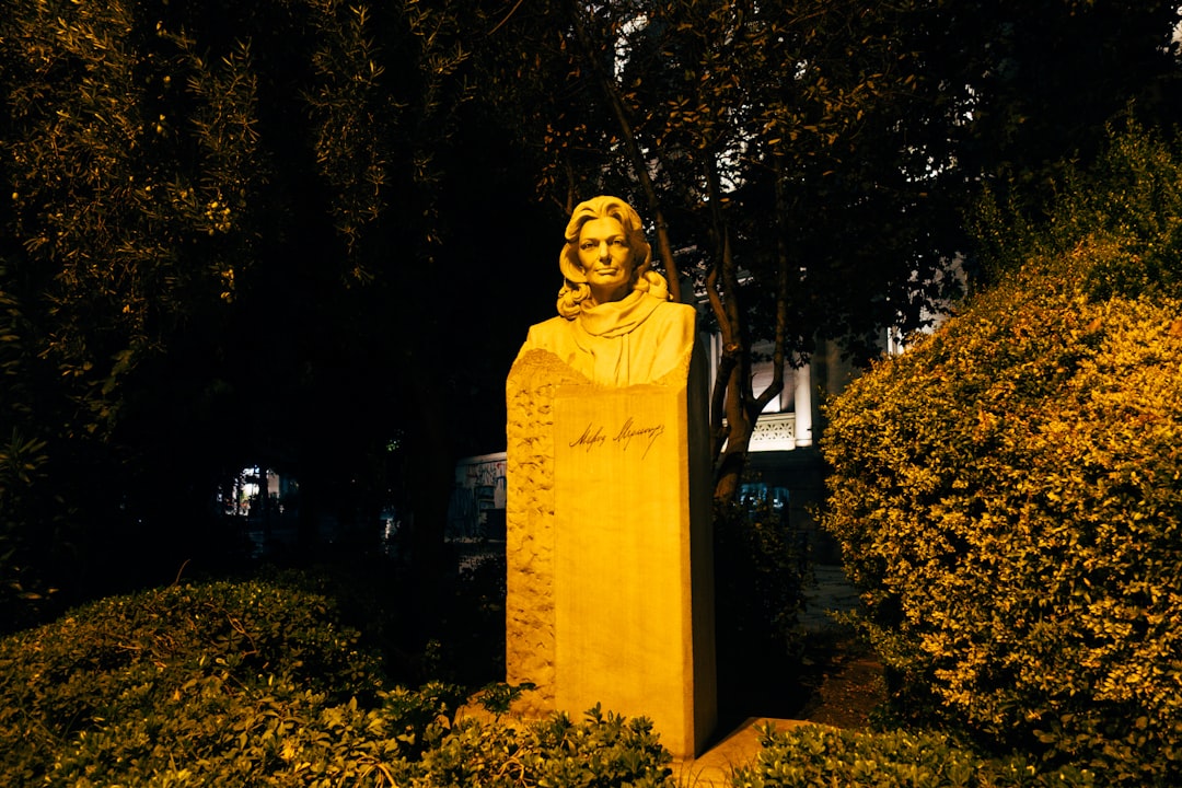 yellow statue near green trees during night time