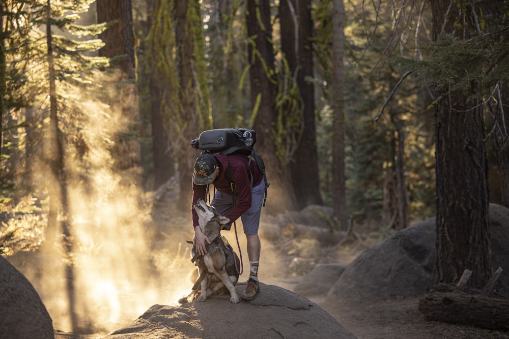 man in black t-shirt and brown pants carrying hiking backpack walking on brown rock during