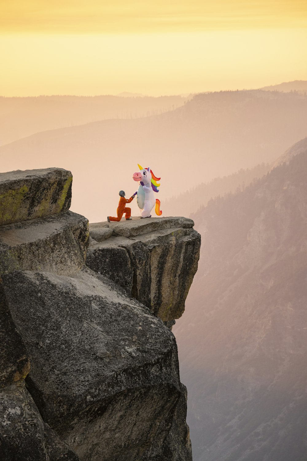 person in white shirt sitting on rock during daytime