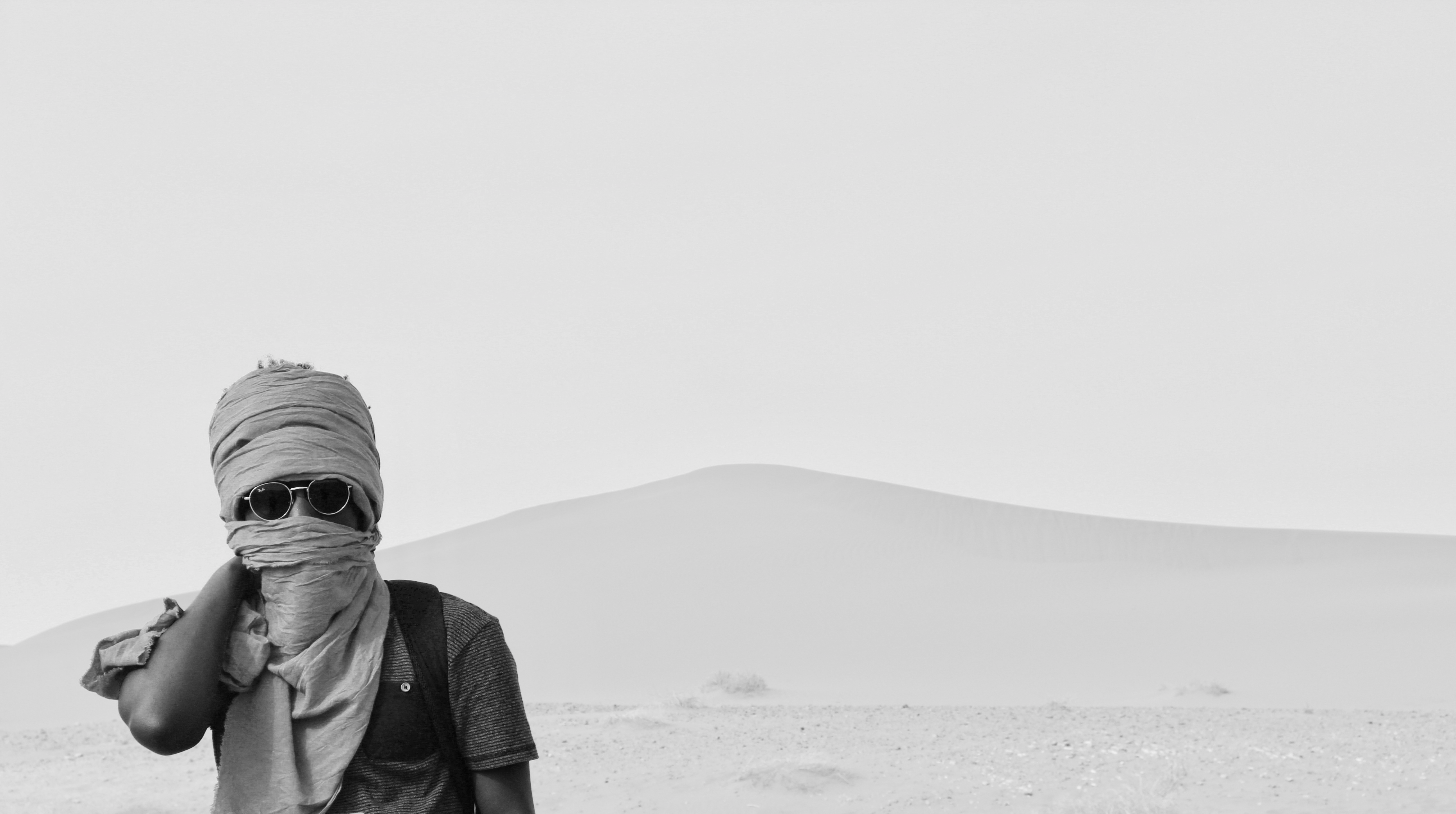 Man in black jacket and black knit cap standing on snow covered ground