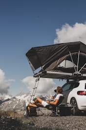 woman in white crew neck t-shirt sitting on white car during daytime