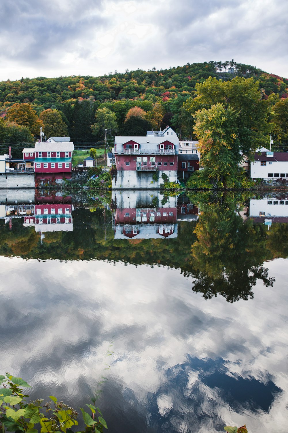 white and red concrete building near green trees under white clouds during daytime