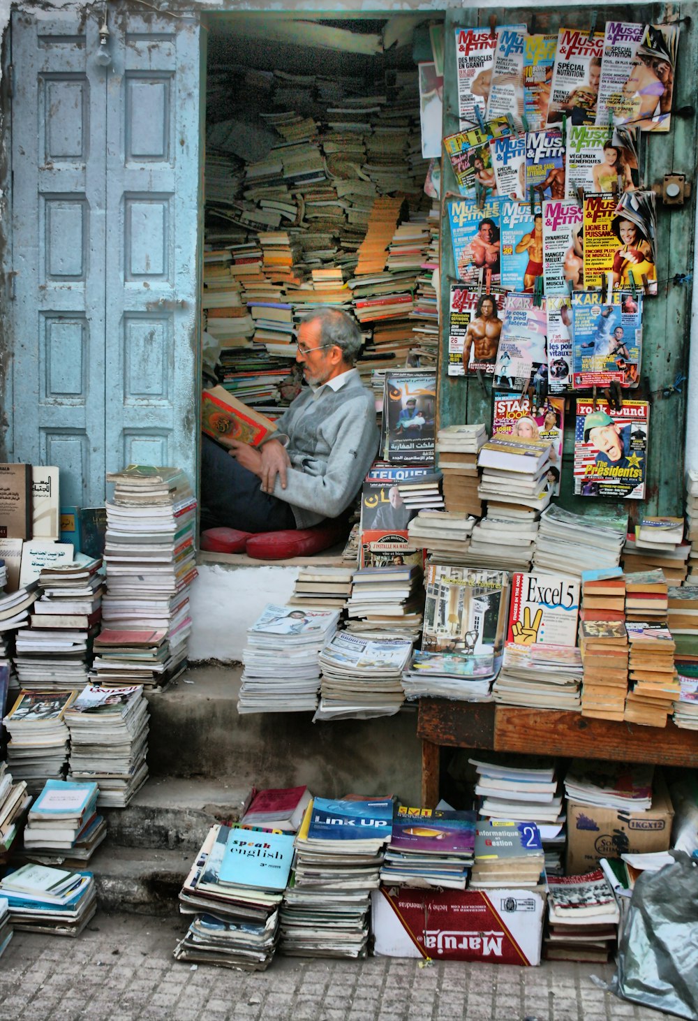 man in blue button up shirt standing in front of books