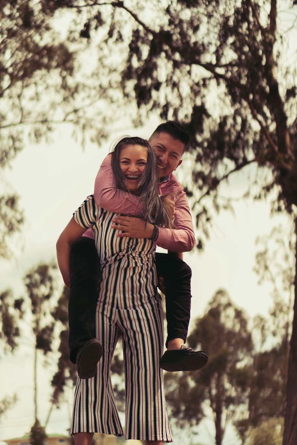 woman in black and white stripe dress hugging man in black shirt