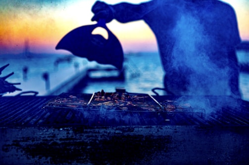 Elegant charcoal grill setup with smoke rising at sunset.