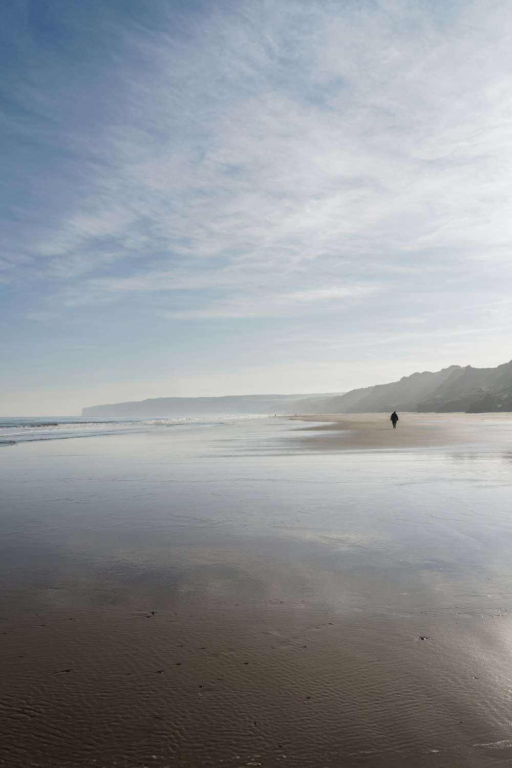 person standing on seashore during daytime