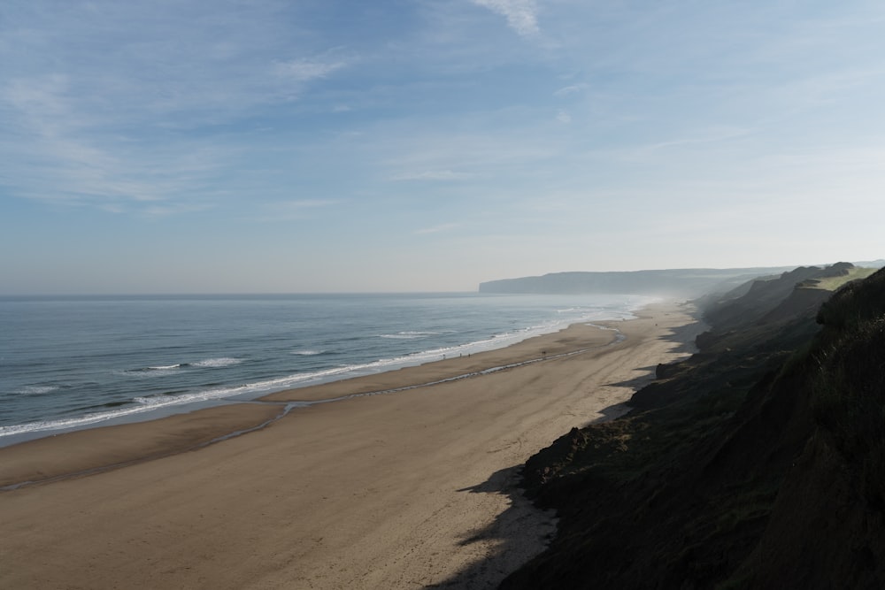 brown sand beach under blue sky during daytime