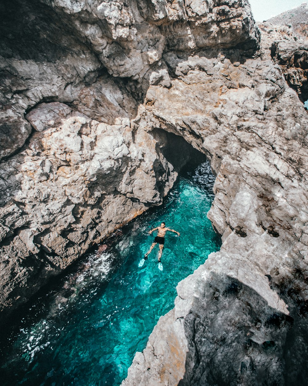 person in blue water in river