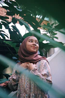 A serene outdoor scene showing a woman in a flowing taupe abaya, her silhouette illuminated by soft evening light.