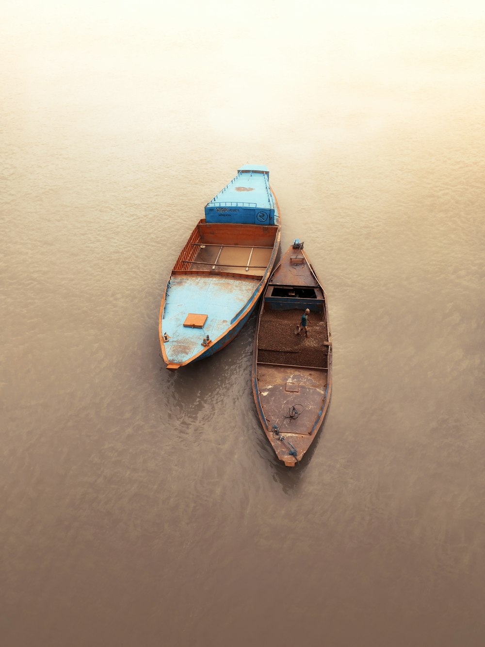 barca di legno blu e marrone sullo specchio d'acqua durante il giorno