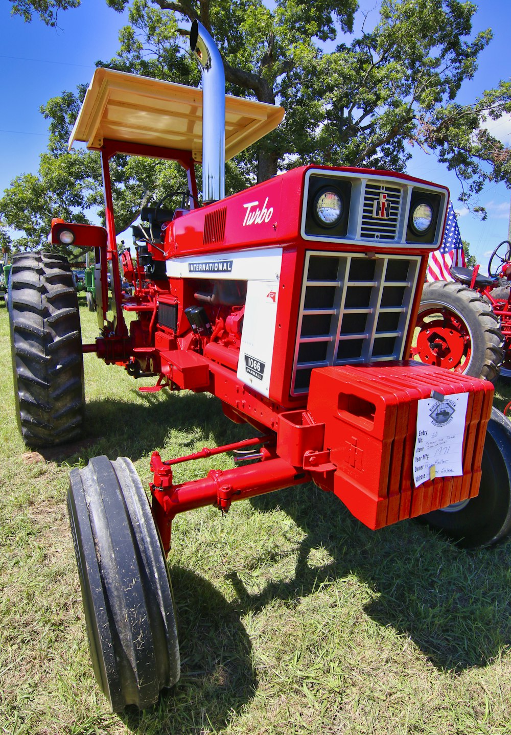 red and black tractor on green grass field during daytime