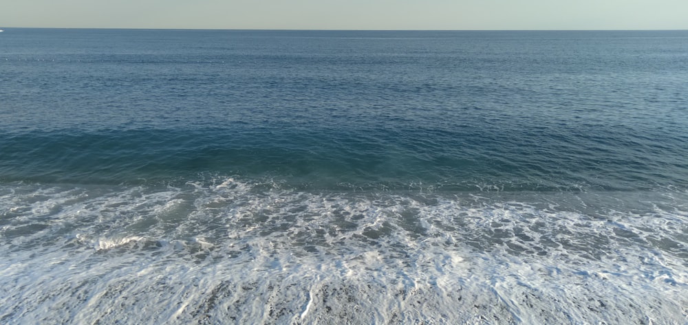 ocean waves crashing on shore during daytime