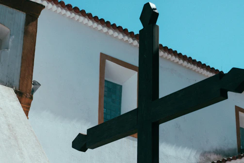black wooden cross on white wall