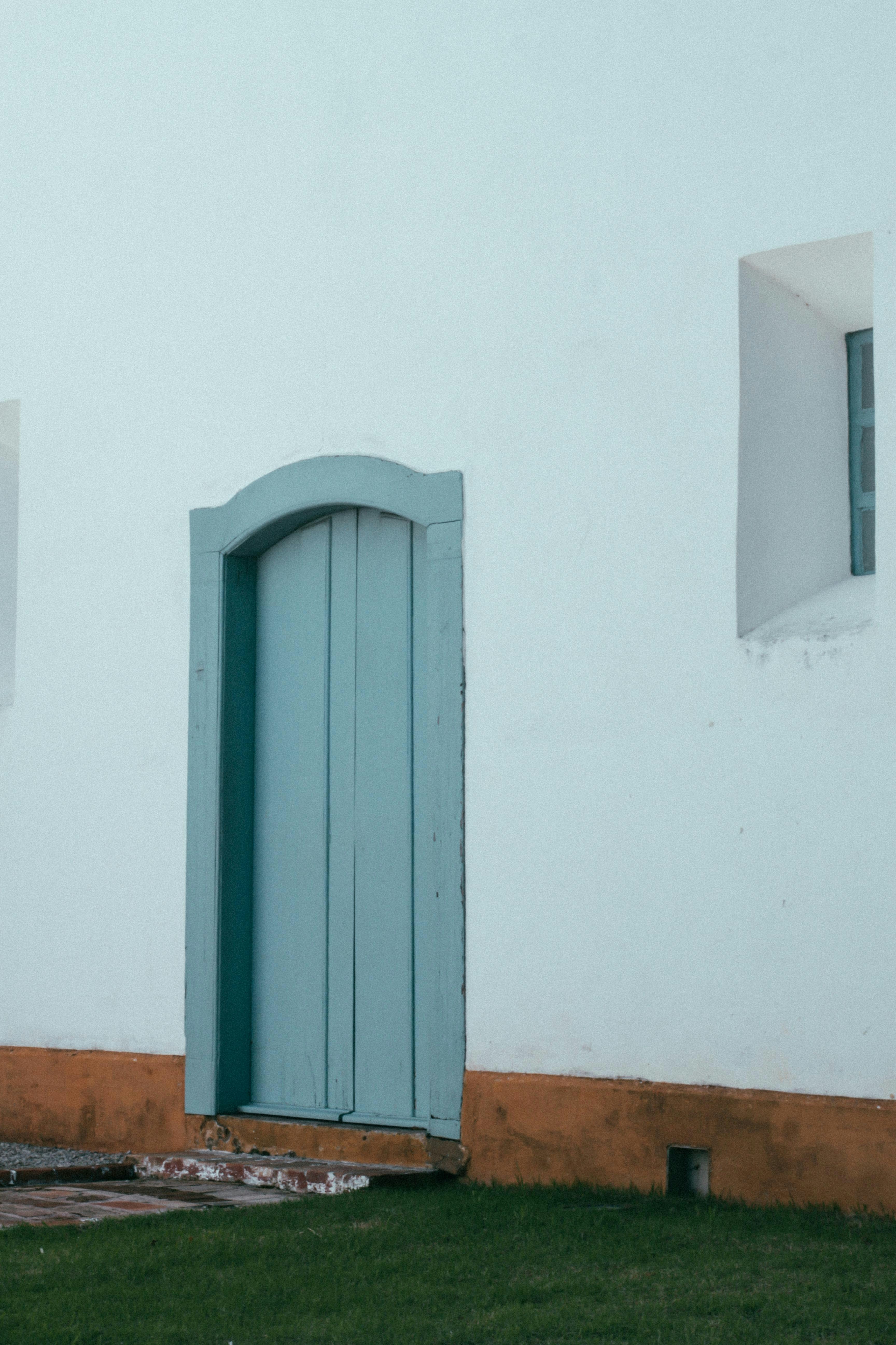 blue wooden door on white painted wall
