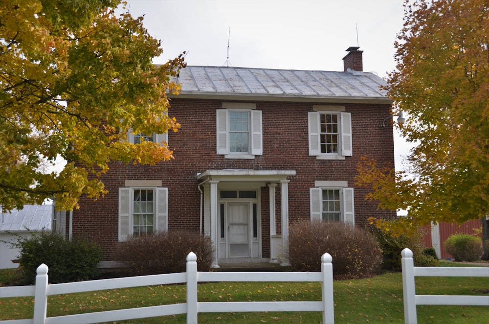 brown and white concrete house near green trees during daytime