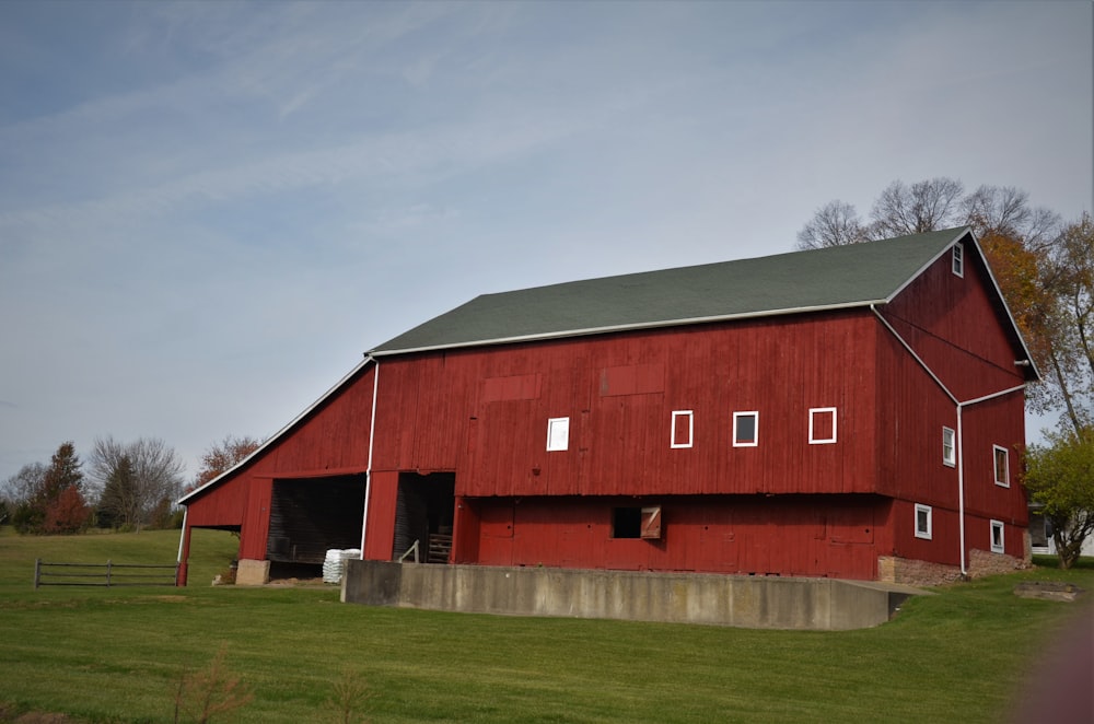 red and black barn house under white clouds