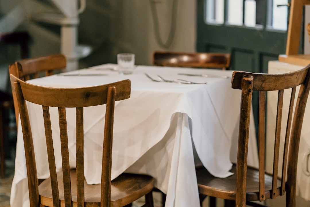 brown wooden chair beside table, An old fashioned table setting in an Italian trattoria