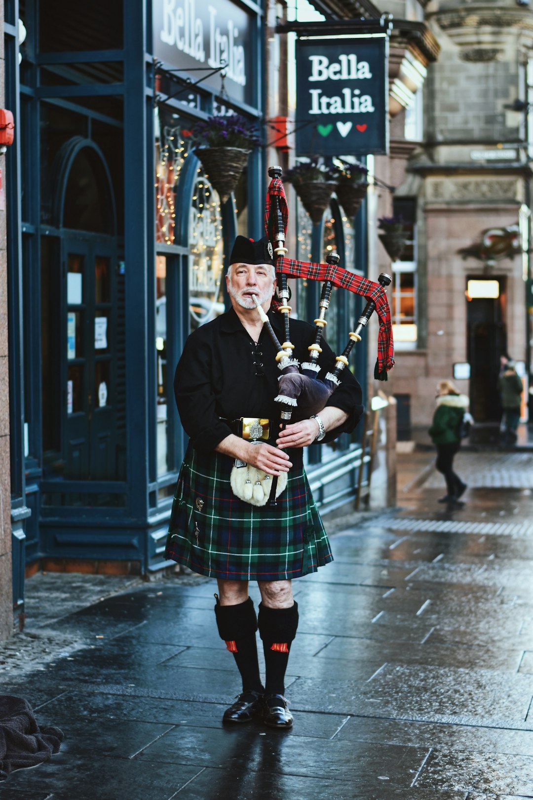 woman in black and white plaid skirt and black coat standing on sidewalk during daytime