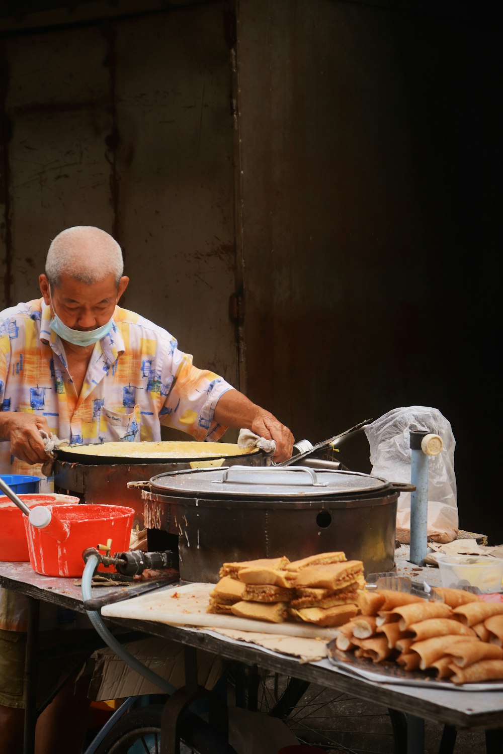 man in blue and white plaid dress shirt holding a knife slicing a food