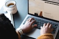 person using macbook pro on black table