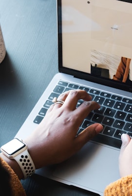 person using macbook pro on black table