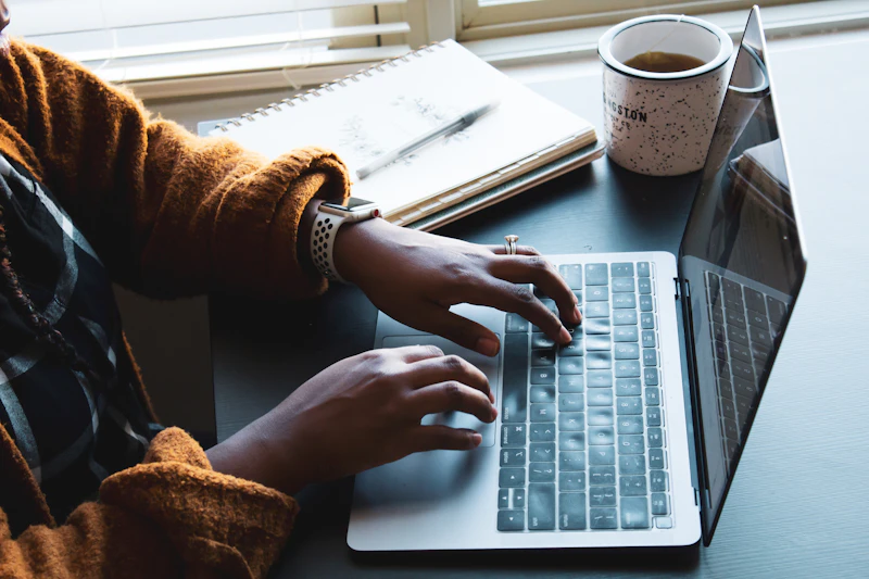 Black professional woman focused on laptop in home office