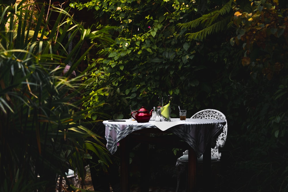 red ceramic teacup on white table cloth