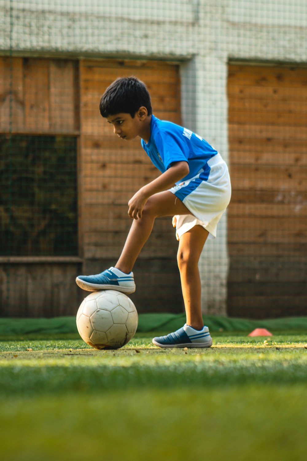 boy in blue and white shirt playing soccer