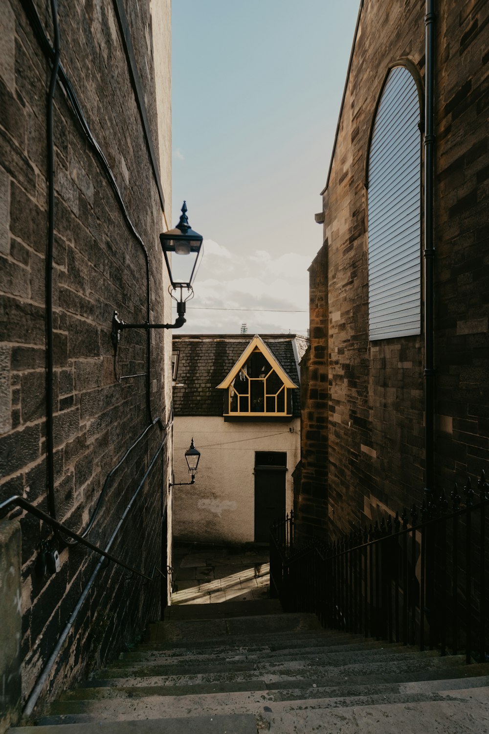 black outdoor lantern on brown brick wall during daytime