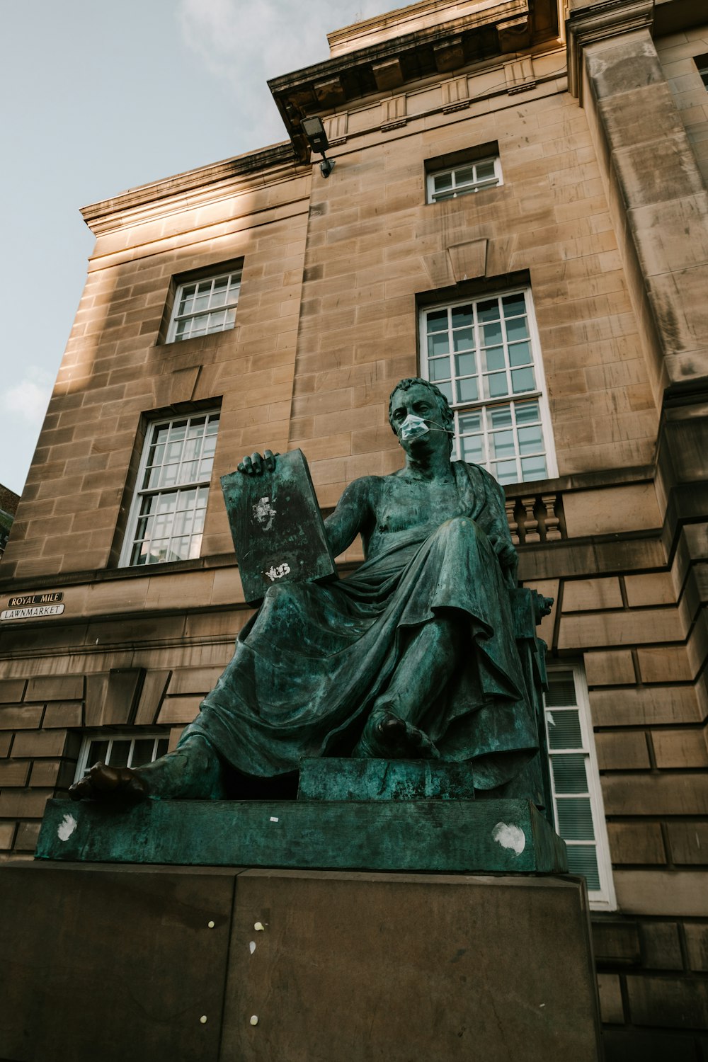 statue of man holding book