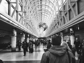 people walking inside building in grayscale photography