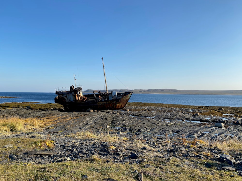 brown and white boat on brown sand during daytime