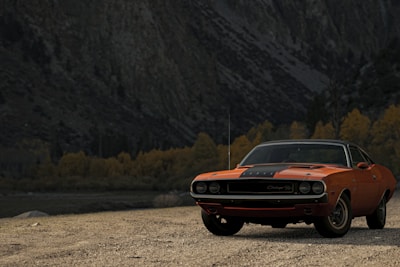 orange chevrolet camaro on dirt road during daytime