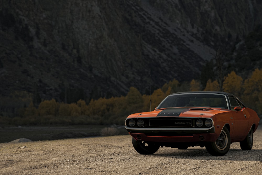 Chevrolet Camaro naranja en camino de tierra durante el día