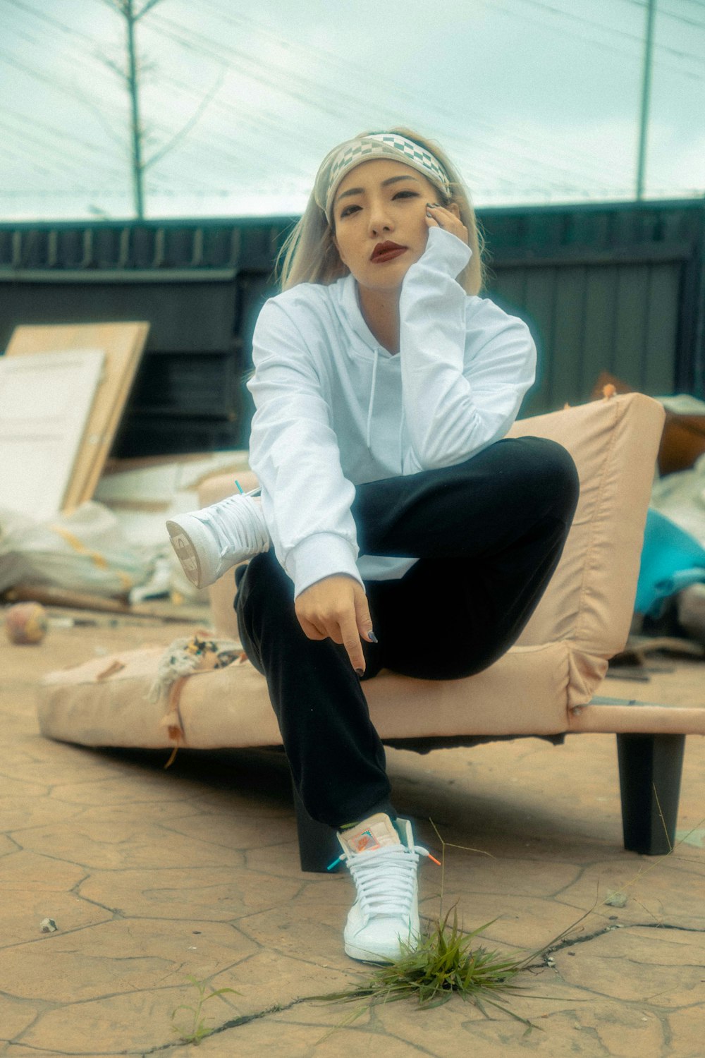 woman in white dress shirt and black pants sitting on brown wooden bench