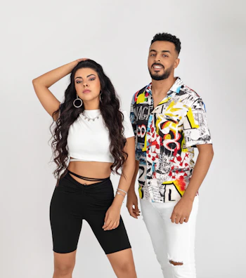 A stylish couple wearing matching premium boubous, standing confidently against a minimalist backdrop.