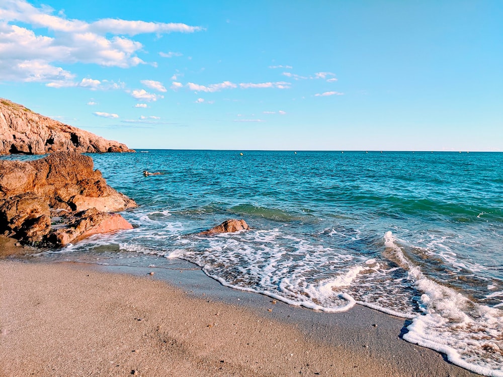 brown rock formation on sea shore during daytime