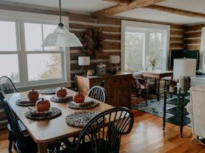 A cozy kitchen table set with autumn-themed dishes and warm lighting.