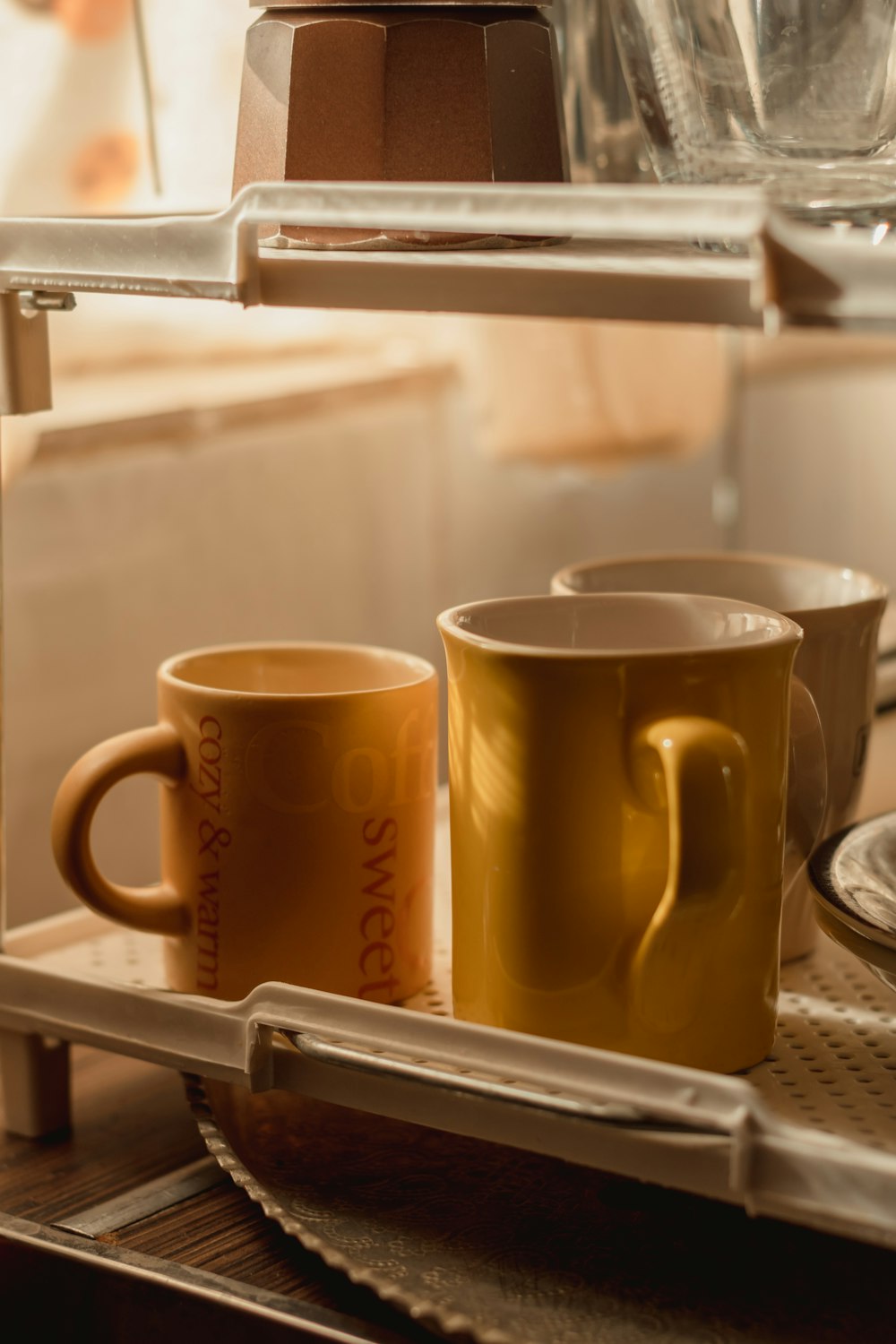 yellow ceramic mug on stainless steel sink