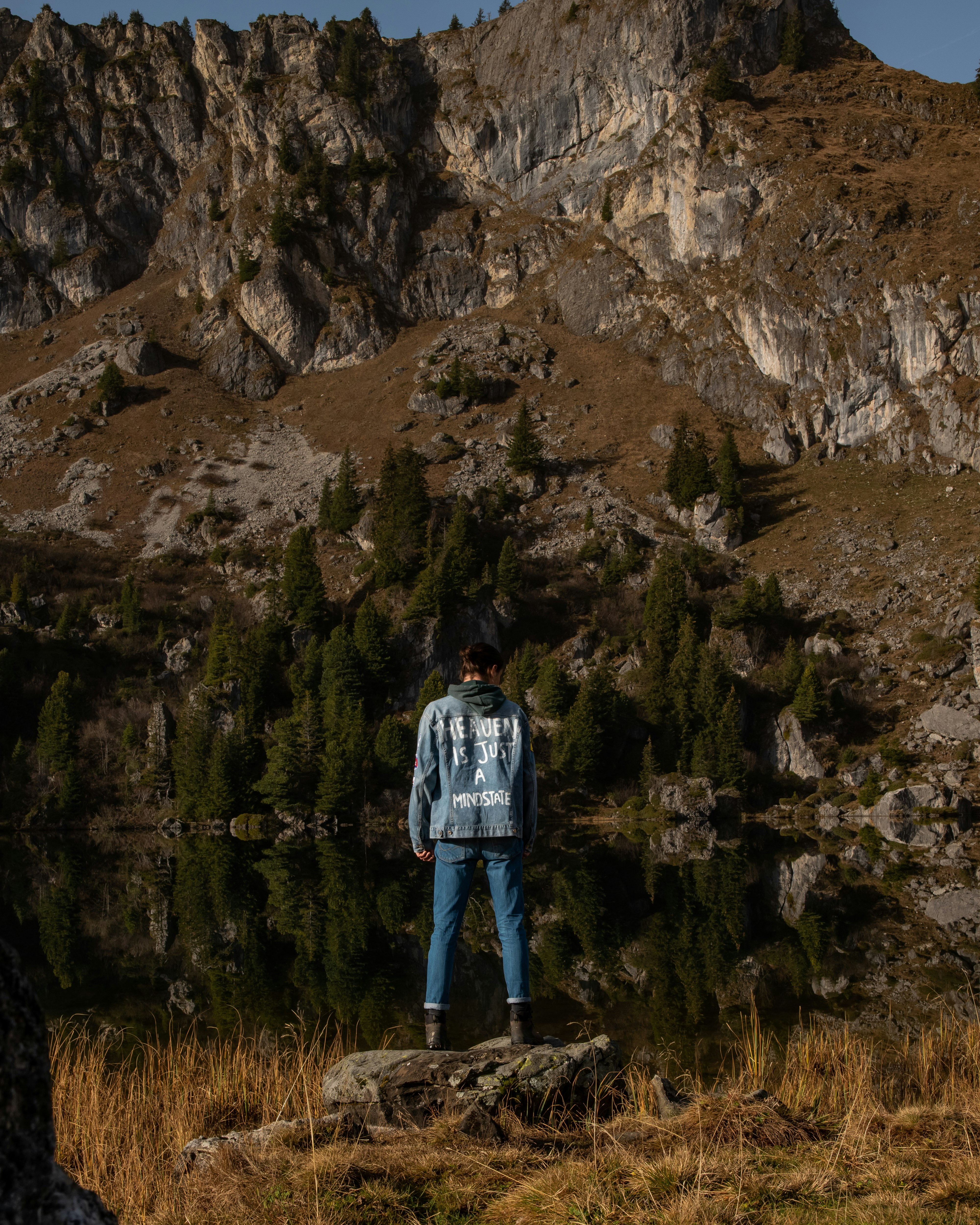 person in blue jacket standing on brown grass field during daytime