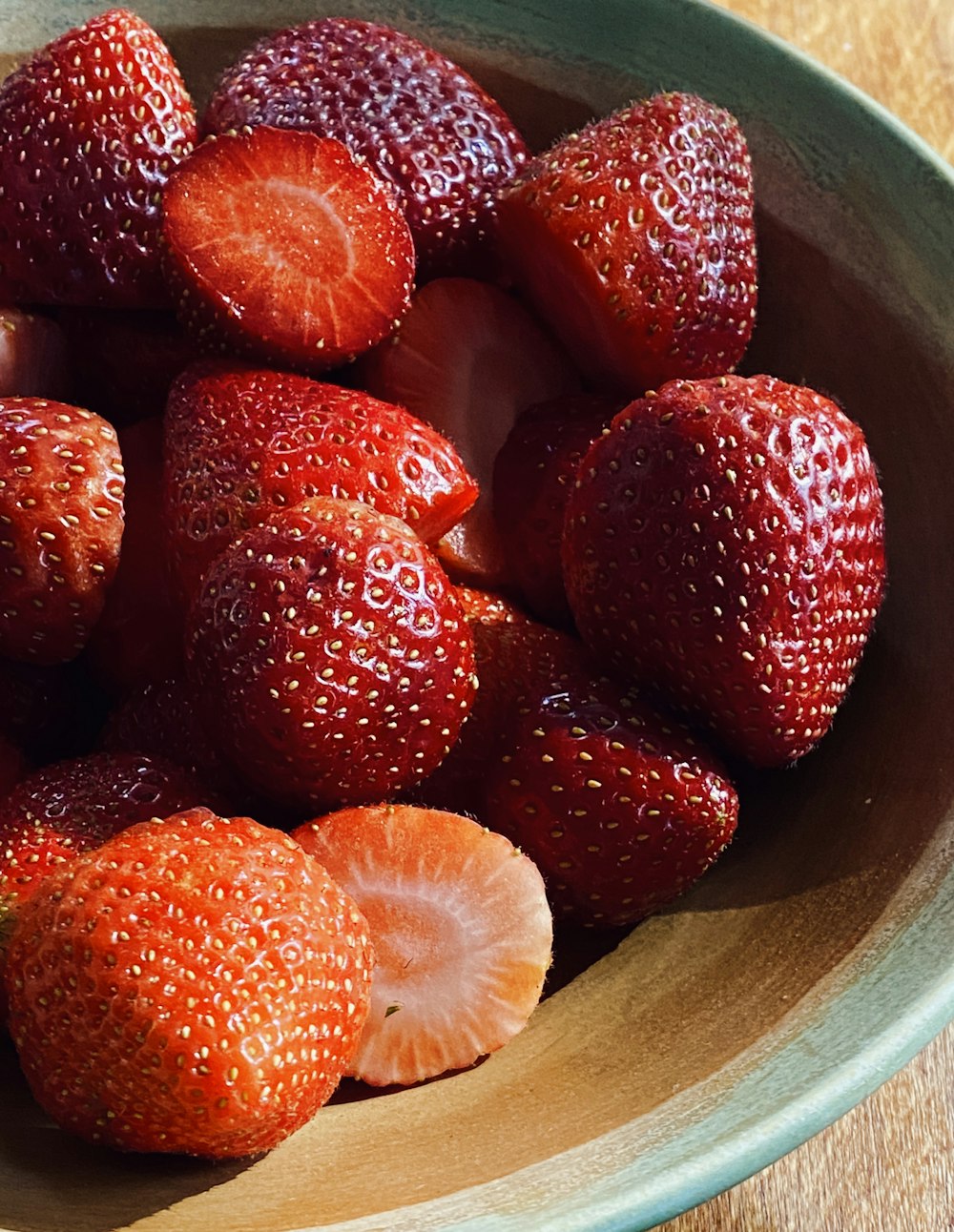 strawberries on brown wooden bowl