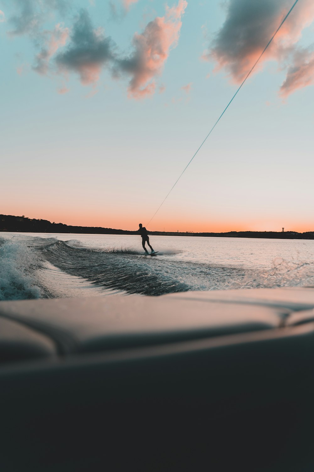 person surfing on sea during sunset