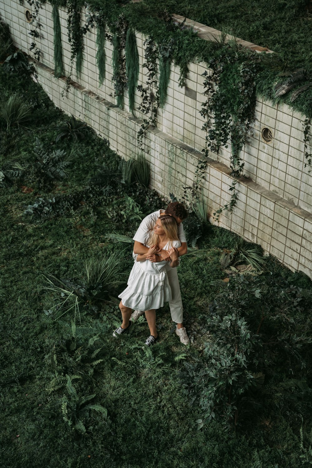 girl in white dress standing on green grass during daytime