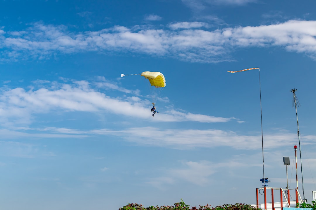 person in yellow parachute under blue sky during daytime