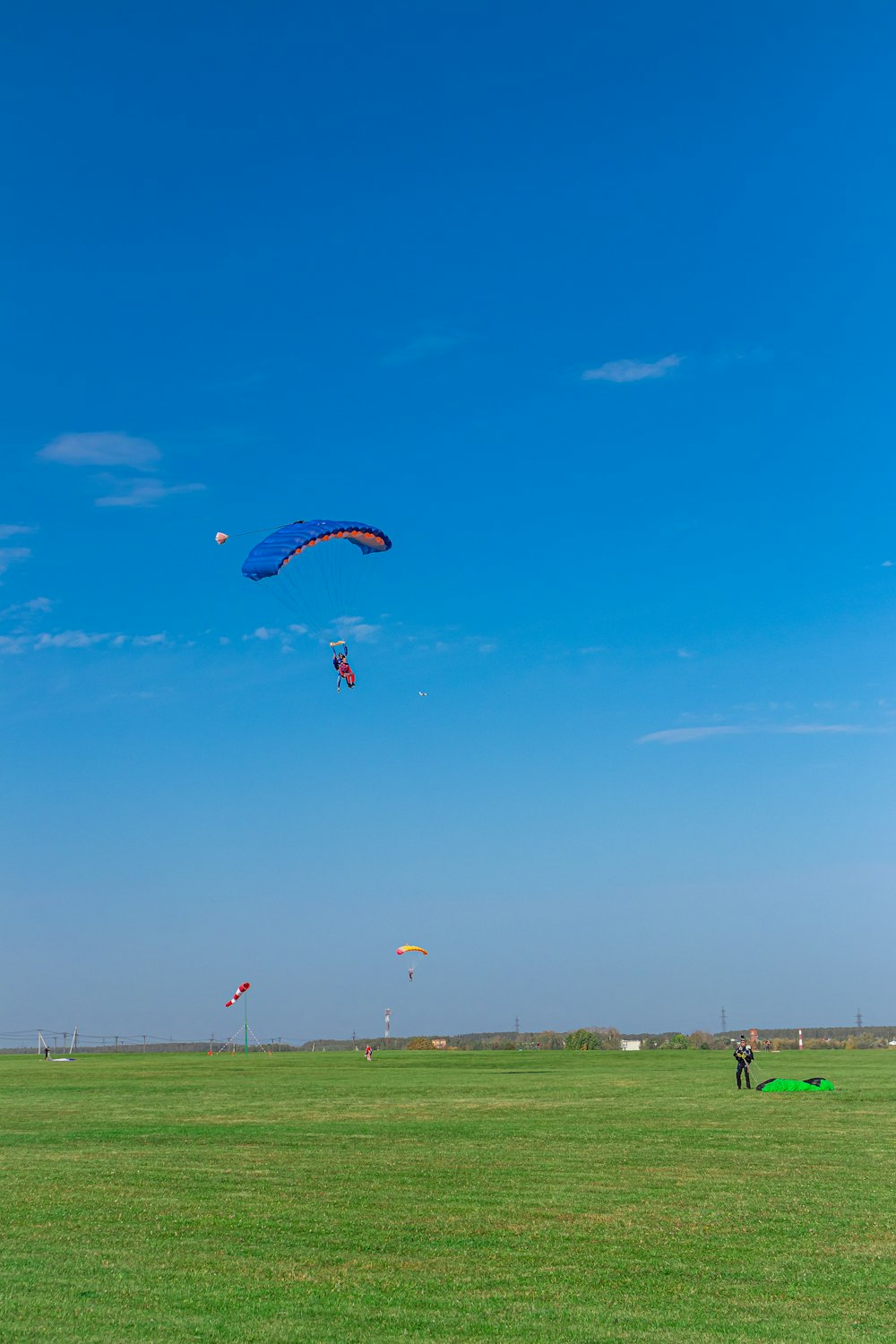 people riding parachute under blue sky during daytime