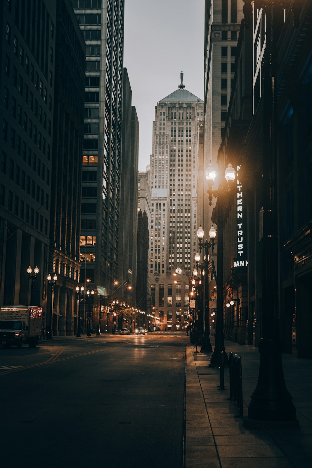 cars on road between high rise buildings during night time