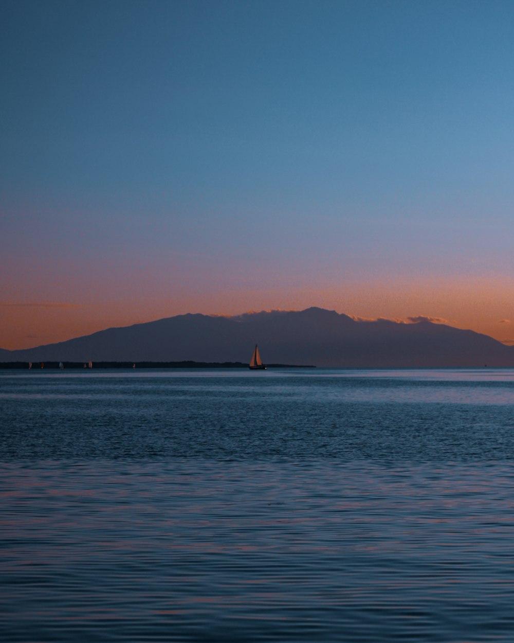 body of water near mountain during daytime